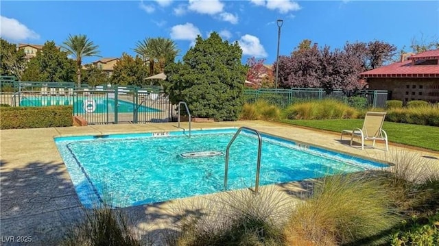 pool featuring fence and a patio