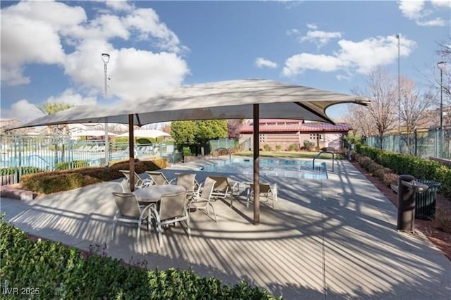 view of patio featuring a community pool and fence