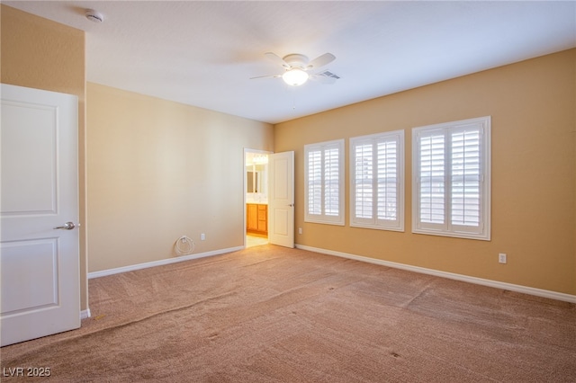 empty room with baseboards, visible vents, a ceiling fan, and light colored carpet