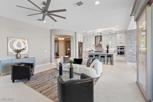 2910 Raywood Ash Dr, Las Vegas, NV 89138 - living room with marble finish floor, arched walkways, ceiling fan, and visible vents