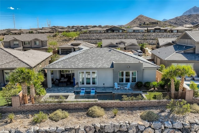 2910 Raywood Ash Dr, Las Vegas, NV 89138 - rear view of house with a fenced backyard, a mountain view, a residential view, and stucco siding