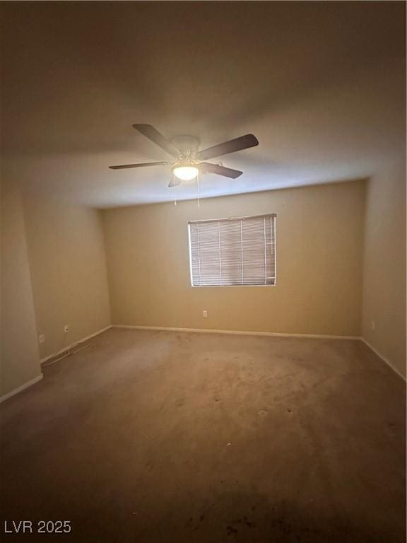 spare room featuring carpet, a ceiling fan, and baseboards