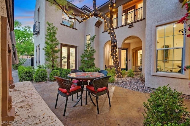 1201 Mersault Ct, Las Vegas, NV 89144 - patio terrace at dusk with outdoor dining space, french doors, and a balcony