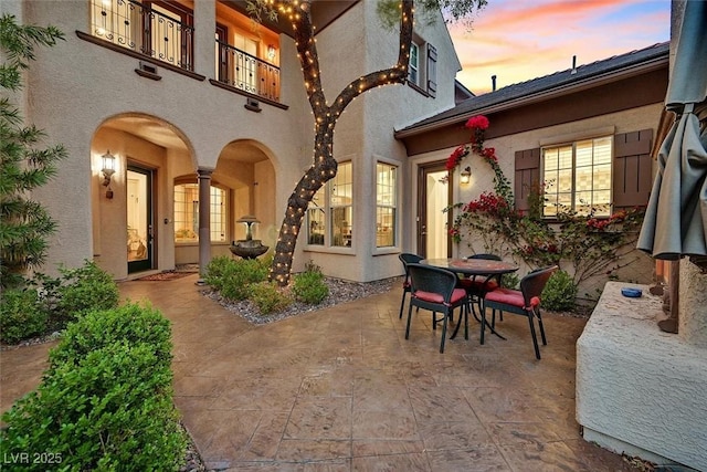 1201 Mersault Ct, Las Vegas, NV 89144 - patio terrace at dusk featuring outdoor dining area and a balcony