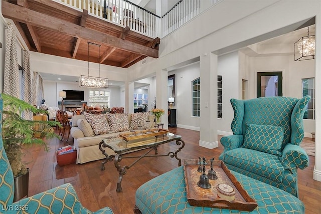 1201 Mersault Ct, Las Vegas, NV 89144 - living area with an inviting chandelier, wood-type flooring, beam ceiling, wood ceiling, and baseboards