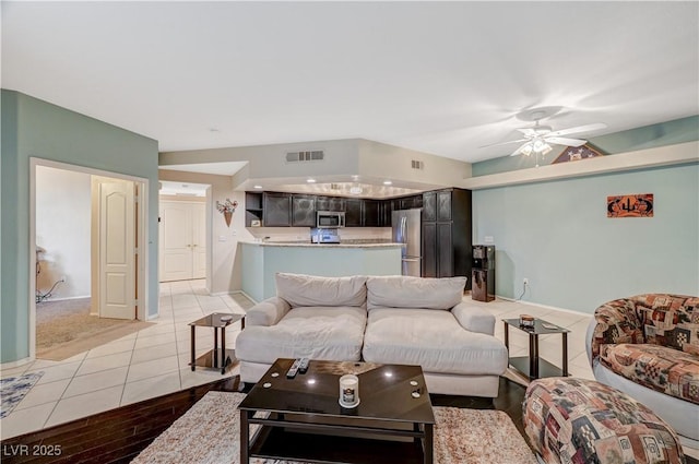 living area with a ceiling fan, light tile patterned flooring, and visible vents