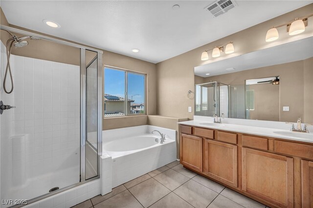 bathroom featuring tile patterned floors, visible vents, a sink, and a stall shower