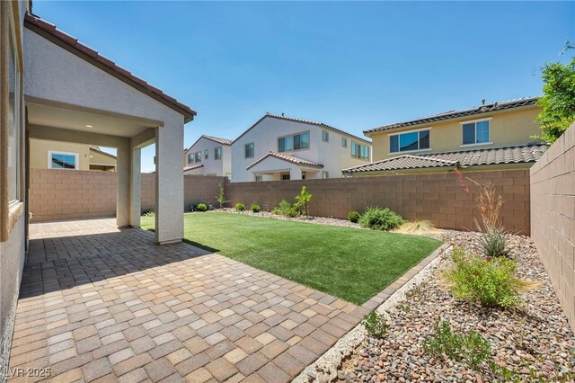 view of yard with a fenced backyard, a residential view, and a patio