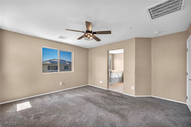 carpeted empty room with visible vents, a ceiling fan, and baseboards