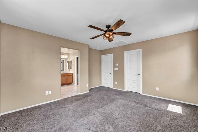 unfurnished bedroom featuring a ceiling fan, baseboards, light carpet, and connected bathroom