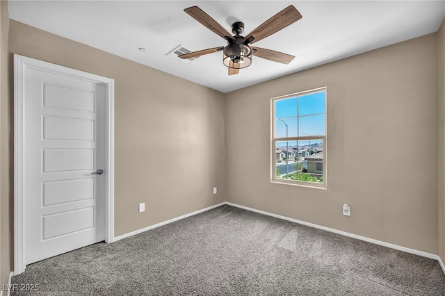 carpeted spare room with baseboards, visible vents, and a ceiling fan