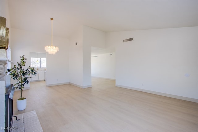3118 Floral Vista Ave, Henderson, NV 89014 - interior space with high vaulted ceiling, an inviting chandelier, light wood-style flooring, baseboards, and visible vents