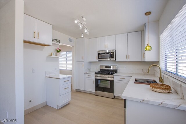 3118 Floral Vista Ave, Henderson, NV 89014 - kitchen featuring white cabinets, a sink, light wood-type flooring, visible vents, and appliances with stainless steel finishes