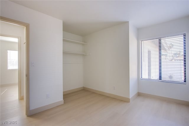 3118 Floral Vista Ave, Henderson, NV 89014 - unfurnished bedroom with baseboards, wood finished floors, a closet, and multiple windows