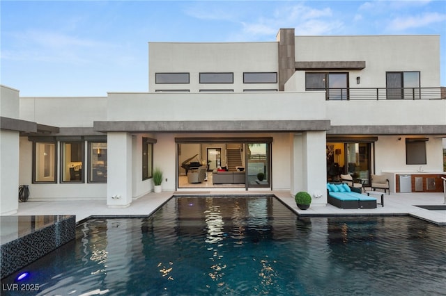back of property featuring a patio, stucco siding, and an outdoor living space