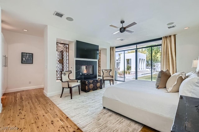 8525 W Verde Way, Las Vegas, NV 89149 - bedroom featuring access to exterior, wood finished floors, a ceiling fan, and a multi sided fireplace