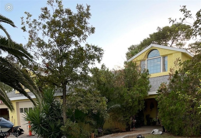 1385 Ringe Ln, Las Vegas, NV 89110 - view of property hidden behind natural elements with stucco siding and a shingled roof