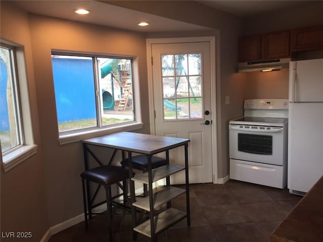 1385 Ringe Ln, Las Vegas, NV 89110 - kitchen with white appliances, under cabinet range hood, recessed lighting, dark tile patterned flooring, and baseboards