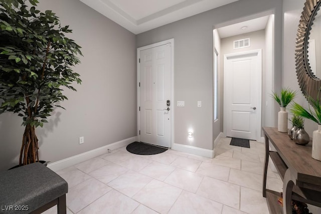 foyer entrance with baseboards, visible vents, and light tile patterned floors
