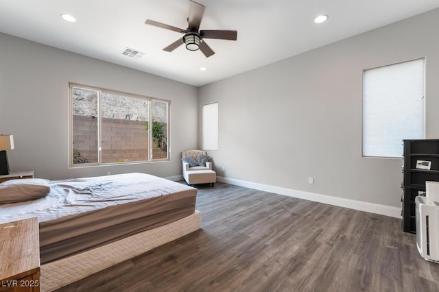 bedroom featuring baseboards, a ceiling fan, visible vents, and dark wood finished floors