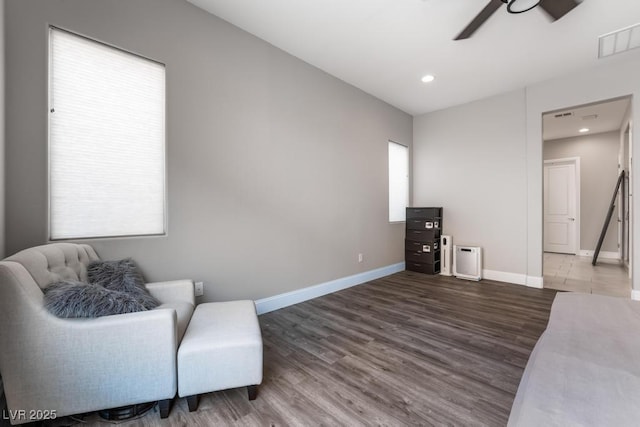 living area with ceiling fan, baseboards, wood finished floors, and visible vents
