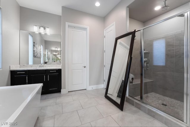 full bath featuring a freestanding tub, vanity, tile patterned floors, and a stall shower