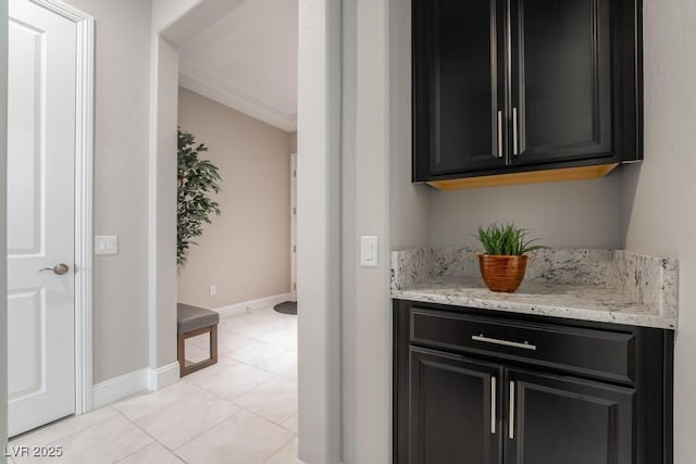 bar featuring baseboards and light tile patterned floors