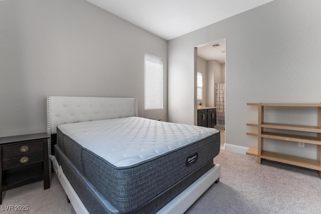 bedroom with ensuite bath and carpet flooring