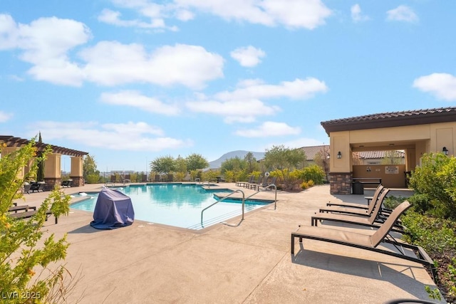 community pool featuring a pergola, a patio, and a mountain view