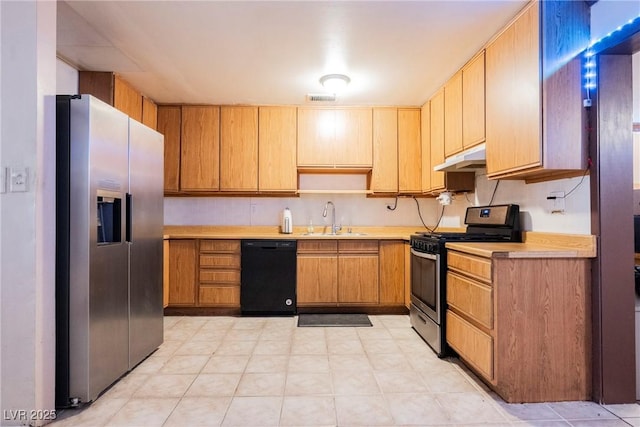 kitchen featuring under cabinet range hood, stainless steel appliances, light countertops, visible vents, and a sink