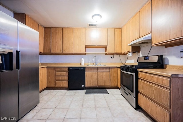 kitchen featuring under cabinet range hood, stainless steel appliances, light countertops, visible vents, and a sink