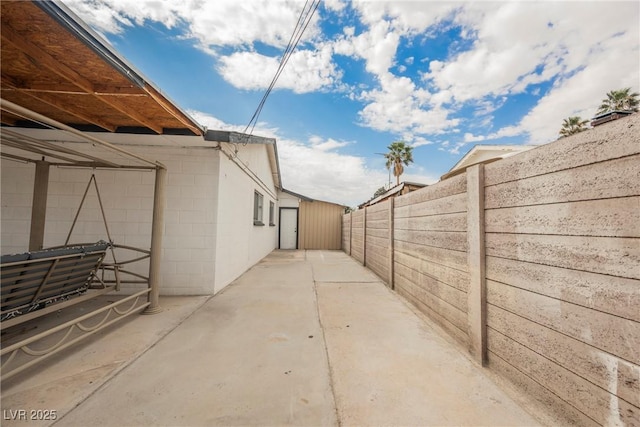view of property exterior featuring fence and a patio area