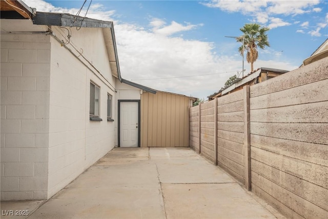 view of side of home with a patio and fence