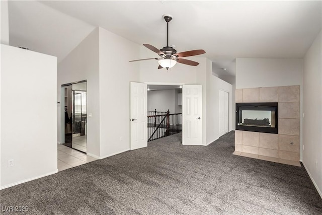 9604 Windom Point Ave, Las Vegas, NV 89129 - unfurnished living room featuring carpet floors, ceiling fan, high vaulted ceiling, a tiled fireplace, and baseboards