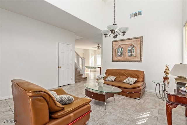 living area with light tile patterned floors, baseboards, visible vents, and stairway