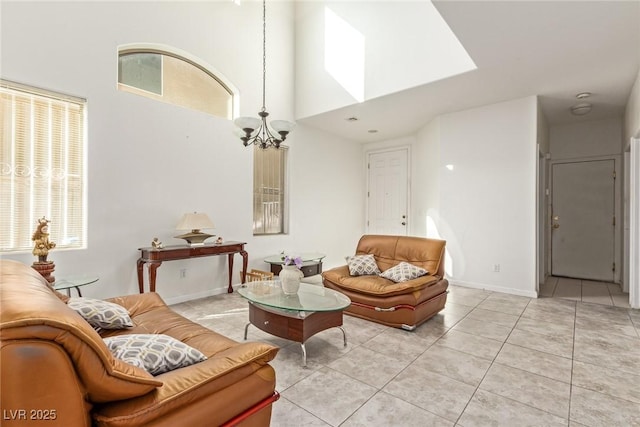 living area with a high ceiling, a notable chandelier, and light tile patterned floors