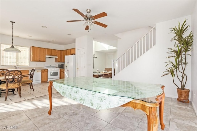 dining area with ceiling fan, stairs, and light tile patterned floors