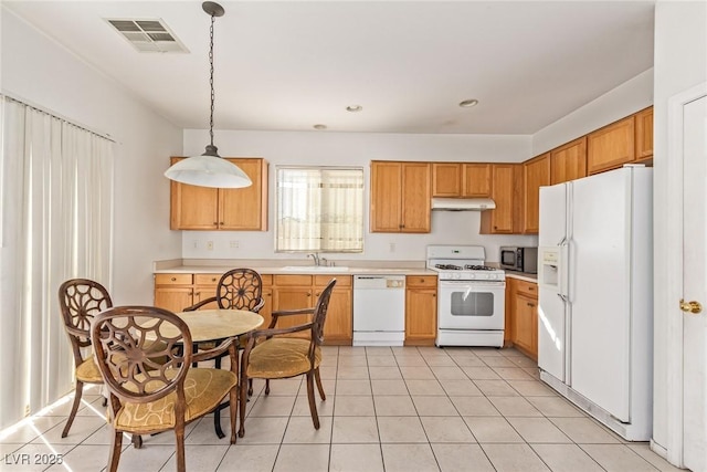 kitchen featuring light countertops, visible vents, under cabinet range hood, and white appliances