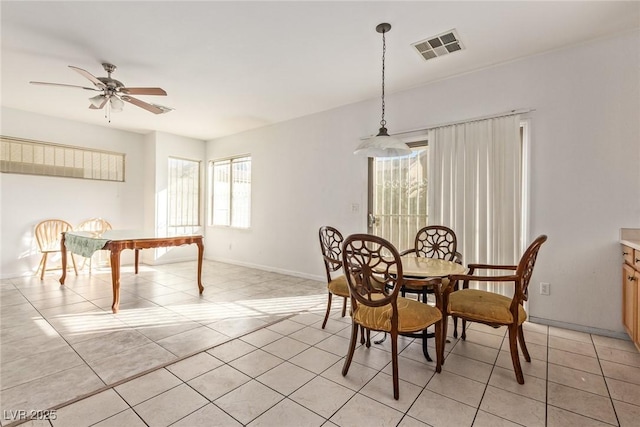 dining space with a wealth of natural light, a ceiling fan, visible vents, and light tile patterned floors