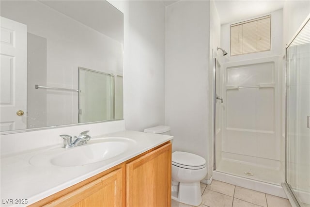 bathroom featuring vanity, tile patterned flooring, a stall shower, and toilet