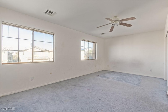carpeted empty room with baseboards, visible vents, and ceiling fan