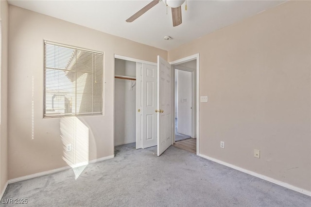 unfurnished bedroom with a closet, carpet flooring, baseboards, and a ceiling fan