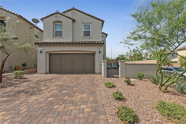 mediterranean / spanish-style house with a gate, a fenced front yard, a tile roof, and stucco siding