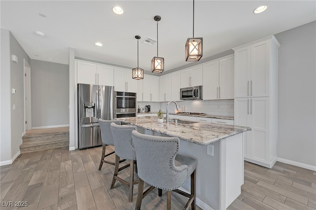 169 Volti Subito Way, Henderson, NV 89011 - kitchen featuring stainless steel appliances, a sink, light wood finished floors, baseboards, and recessed lighting