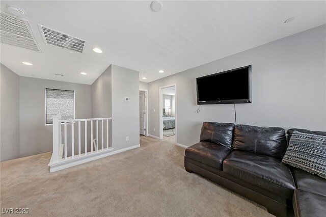 living room with recessed lighting, plenty of natural light, visible vents, and light colored carpet