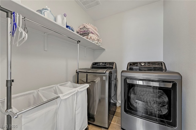 laundry room with separate washer and dryer, visible vents, light wood finished floors, and laundry area