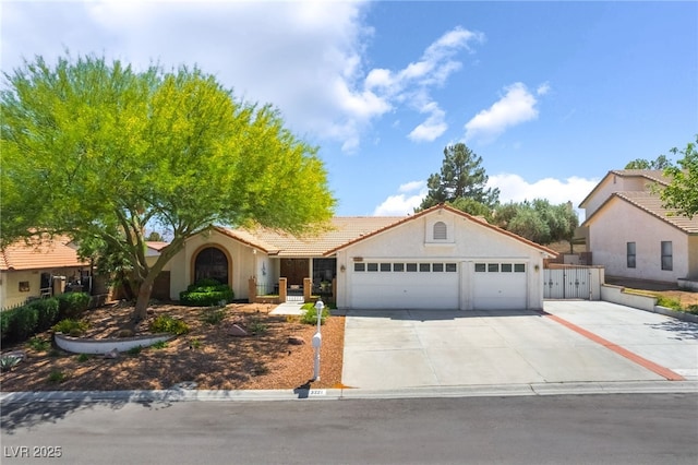 mediterranean / spanish-style home with a garage, concrete driveway, stucco siding, and a tile roof