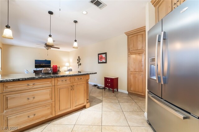 kitchen featuring stainless steel fridge with ice dispenser, ceiling fan, decorative light fixtures, dark stone counters, and light tile patterned floors