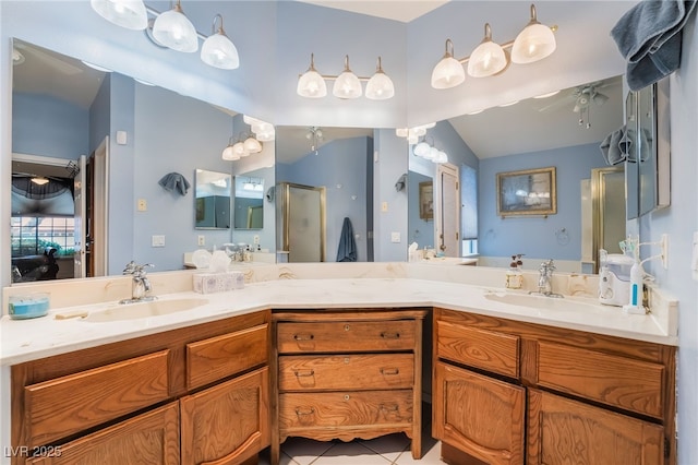 ensuite bathroom with double vanity, a shower with shower door, vaulted ceiling, and tile patterned flooring