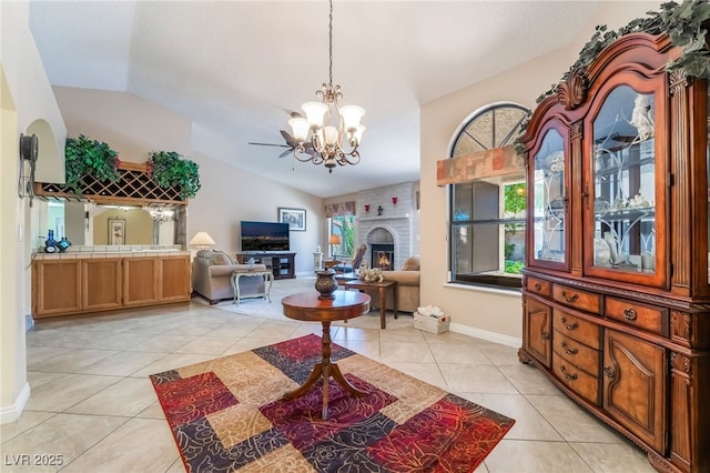 foyer entrance featuring lofted ceiling, a chandelier, plenty of natural light, light tile patterned floors, and a brick fireplace